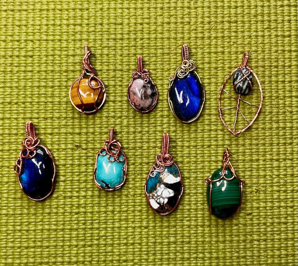 Wire-wrapped gemstone pendants on display